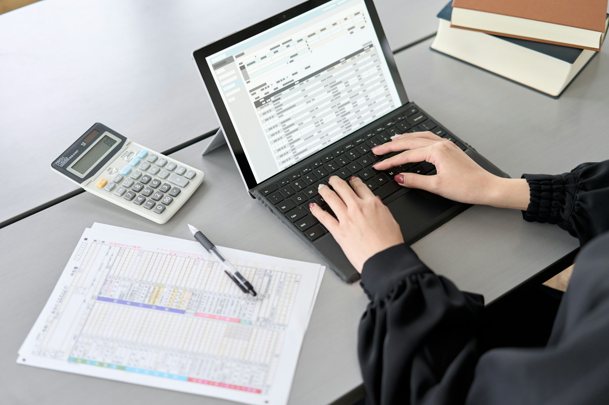 Asian woman entering journal entries in accounting software